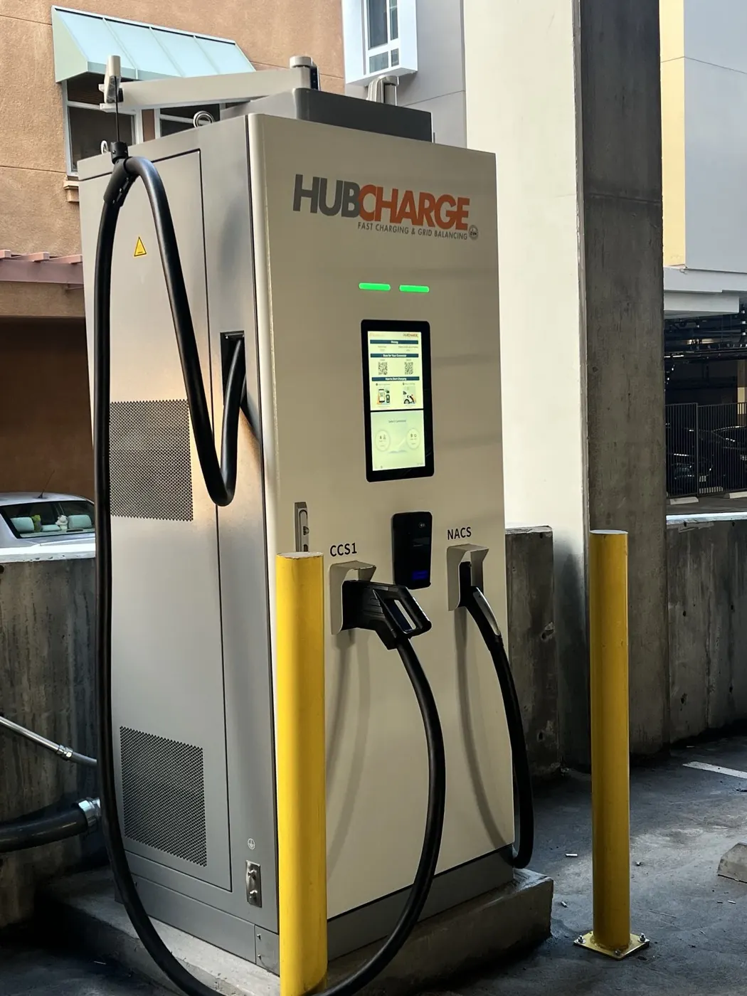 Full view of a HubCharge charger at Alhambra between yellow bollards