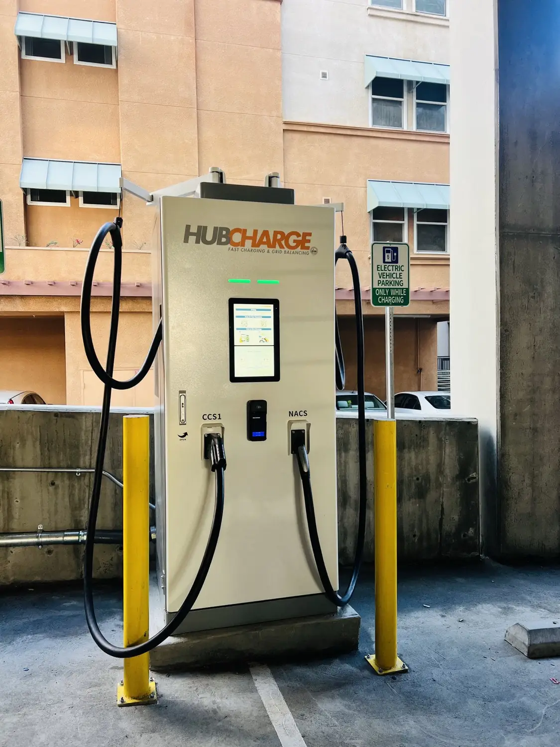 A HubCharge fast charger in the Alhambra parking structure, screen lit and status bars green